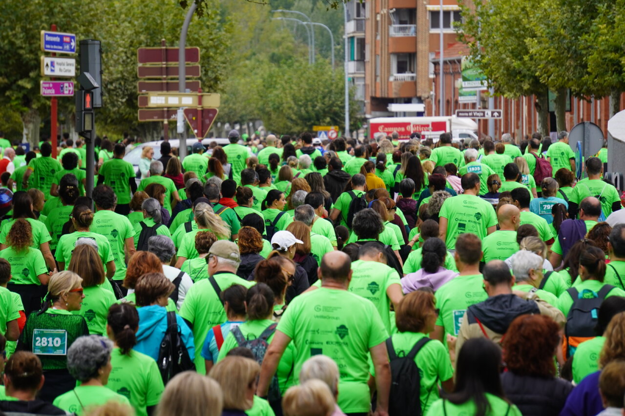 Participantes con camisetas verdes en la carrera contra el cáncer en Palencia