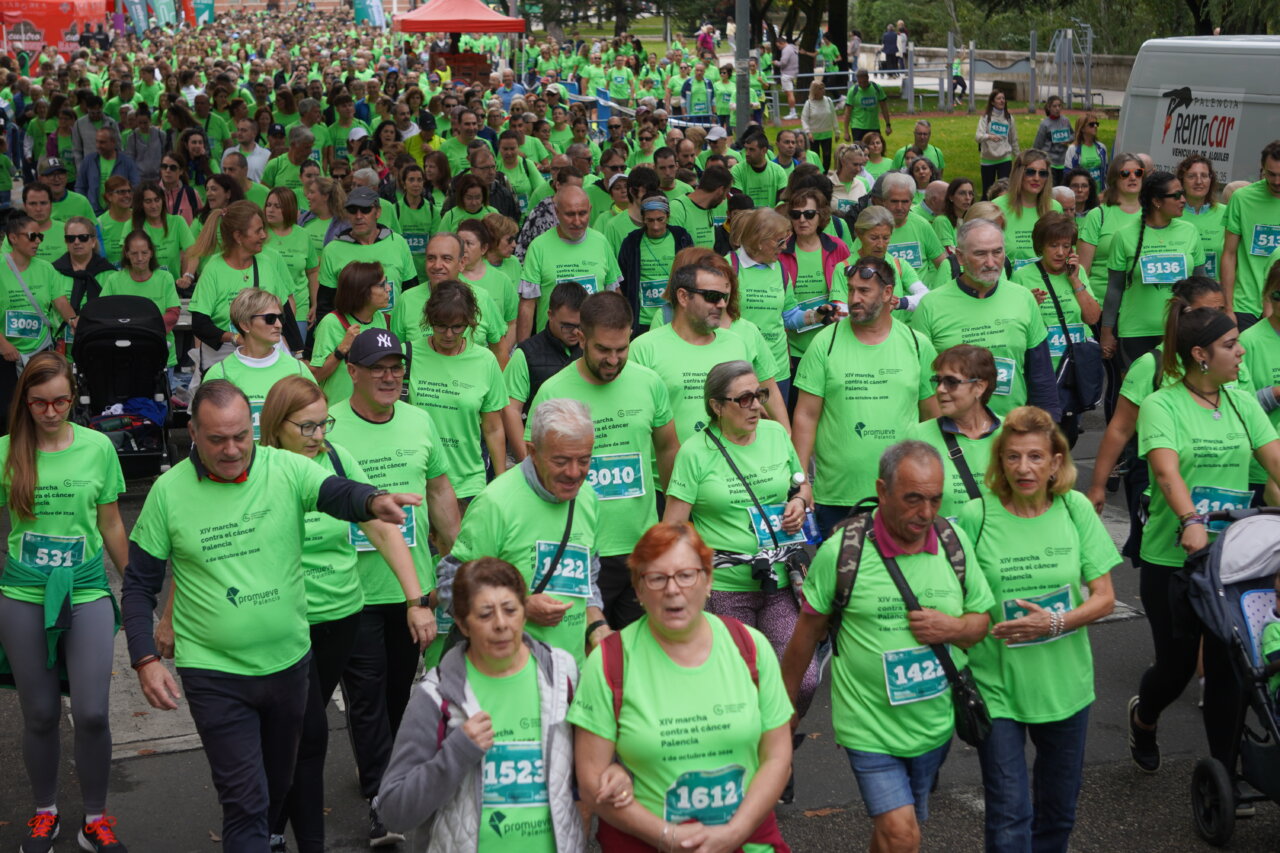 Participantes en la carrera contra el cáncer vistiendo camisetas verdes en Palencia