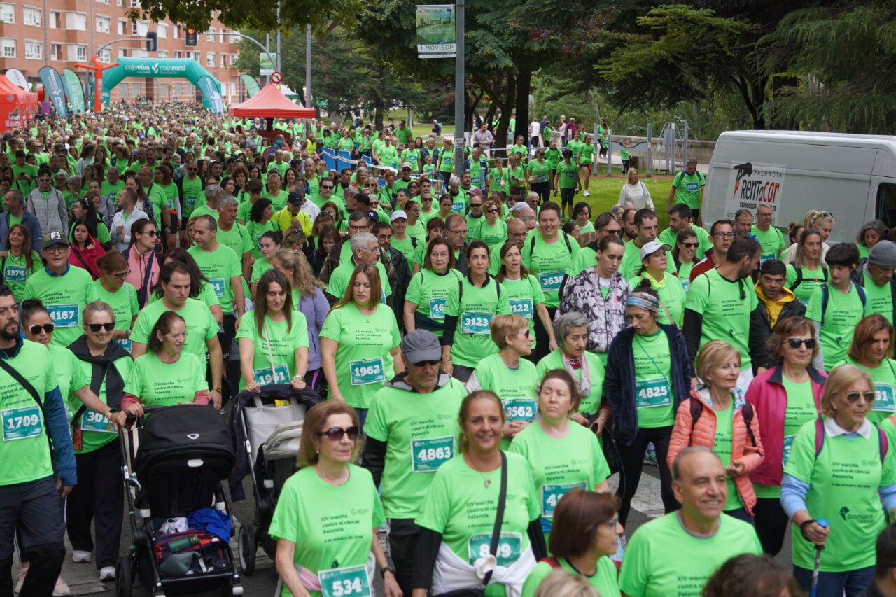 Participantes en la carrera contra el cáncer vistiendo camisetas verdes en Palencia