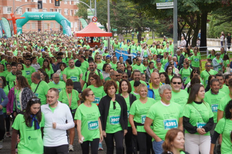 Participantes con camisetas verdes en la Carrera contra el Cáncer en Palencia.
