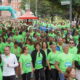 Participantes con camisetas verdes en la Carrera contra el Cáncer en Palencia.