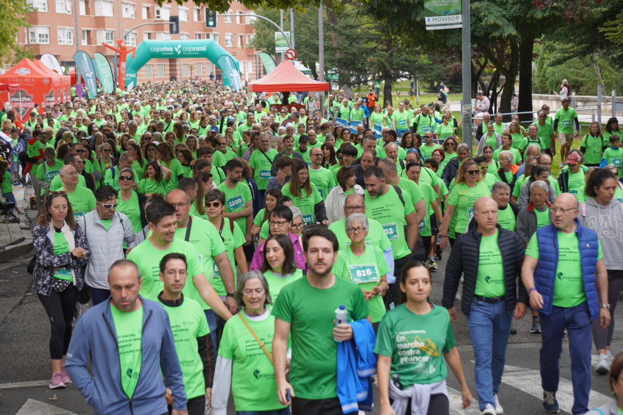 Participantes en la carrera contra el cáncer vistiendo camisetas verdes en Palencia