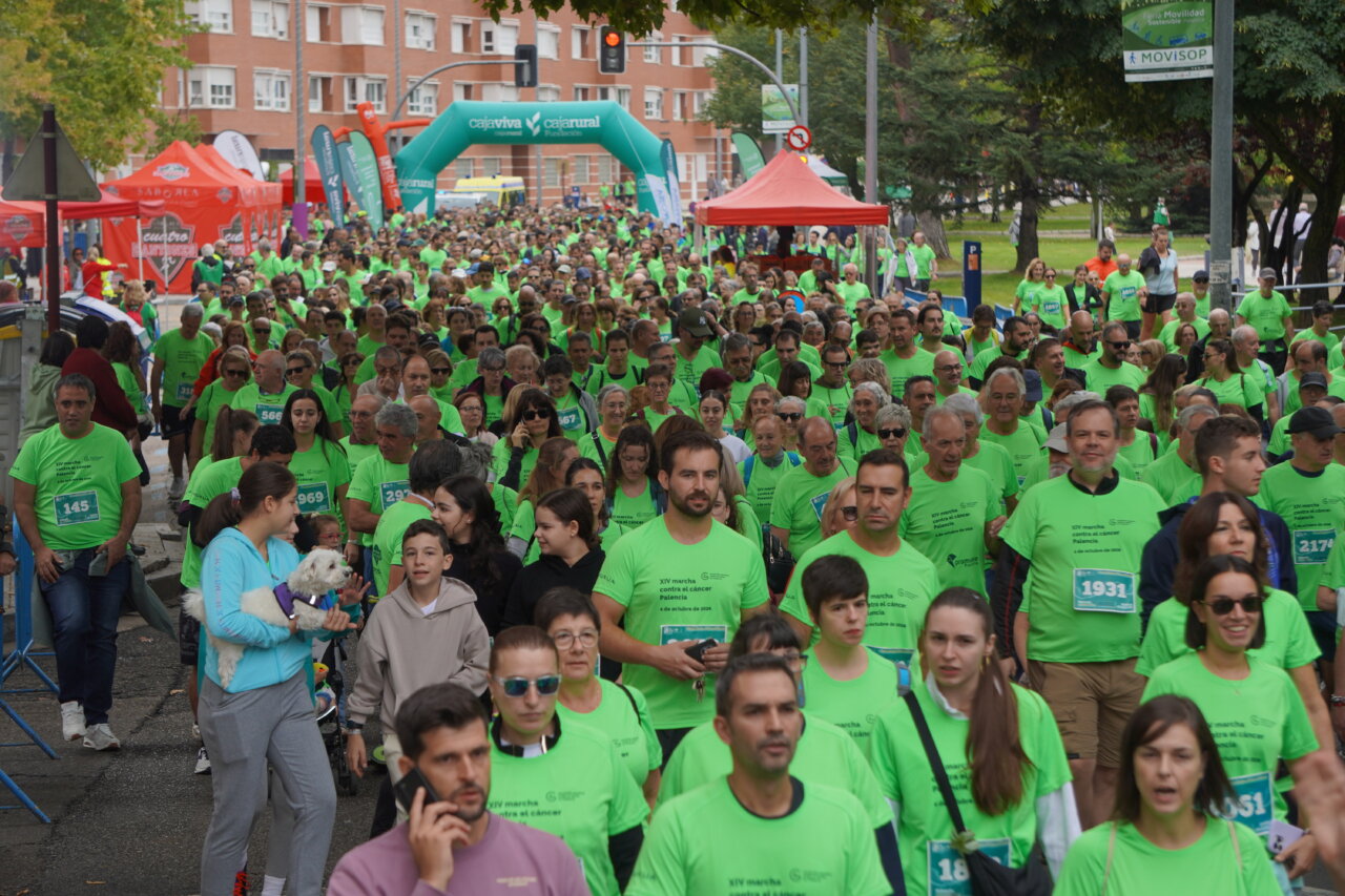 Multitud de personas con camisetas verdes en la Carrera contra el Cáncer en Palencia