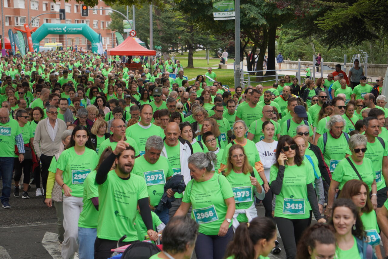 Participantes con camisetas verdes en la Carrera contra el Cáncer en Palencia