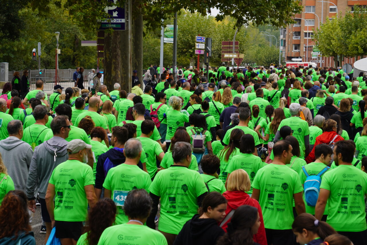 Multitud de personas con camisetas verdes en una carrera contra el cáncer