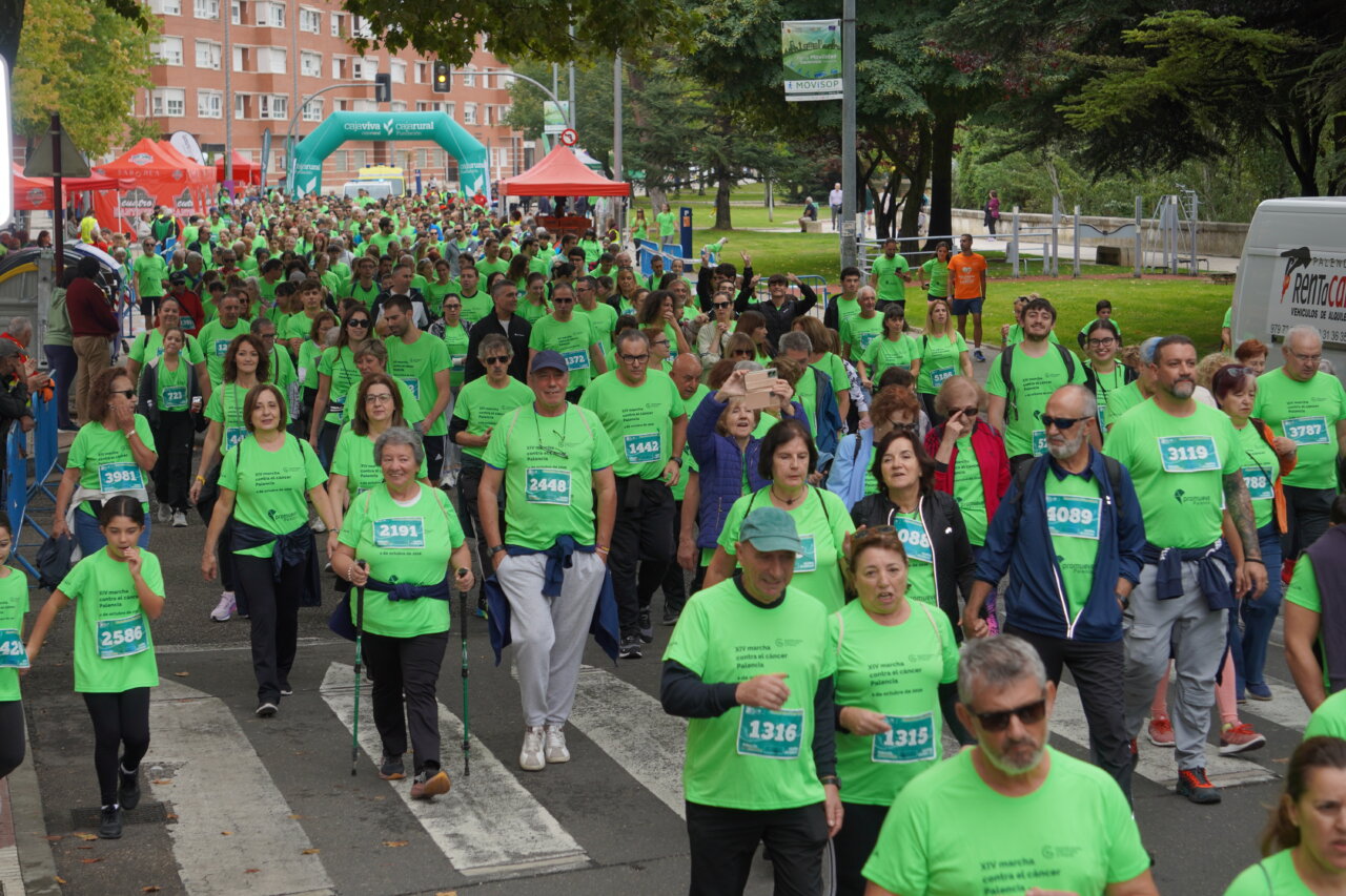 Participantes en la carrera contra el cáncer vistiendo camisetas verdes en Palencia