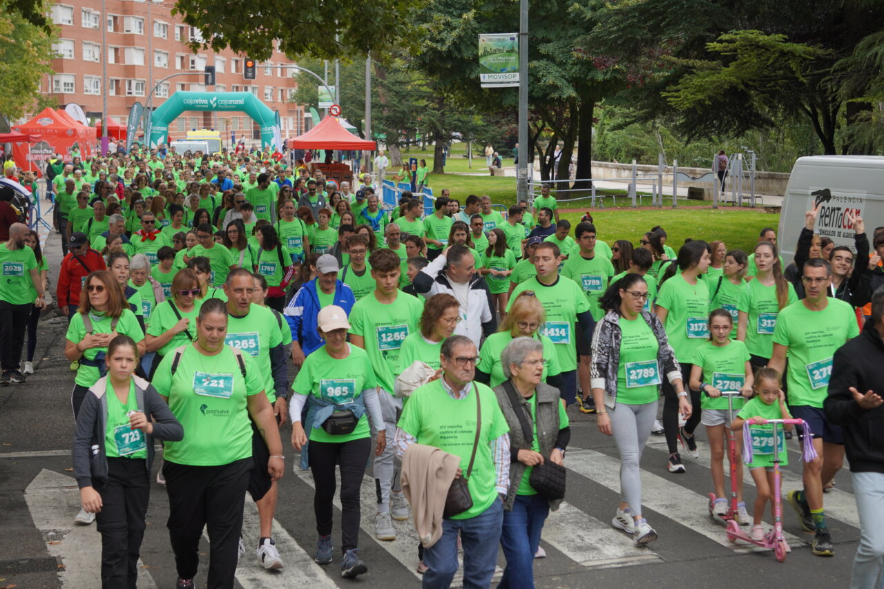 Participantes en la carrera contra el cáncer vistiendo camisetas verdes en Palencia