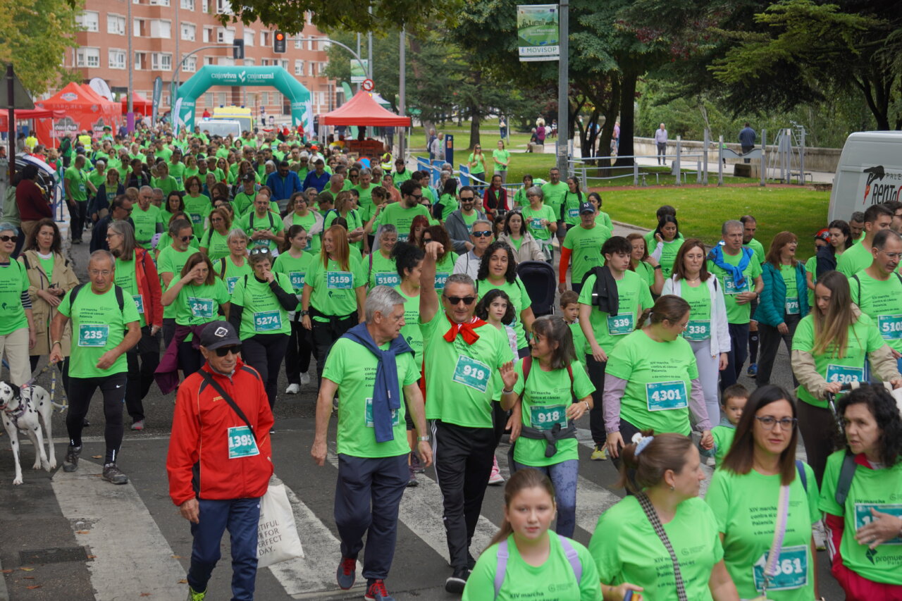 Participantes en la carrera contra el cáncer vistiendo camisetas verdes en Palencia.