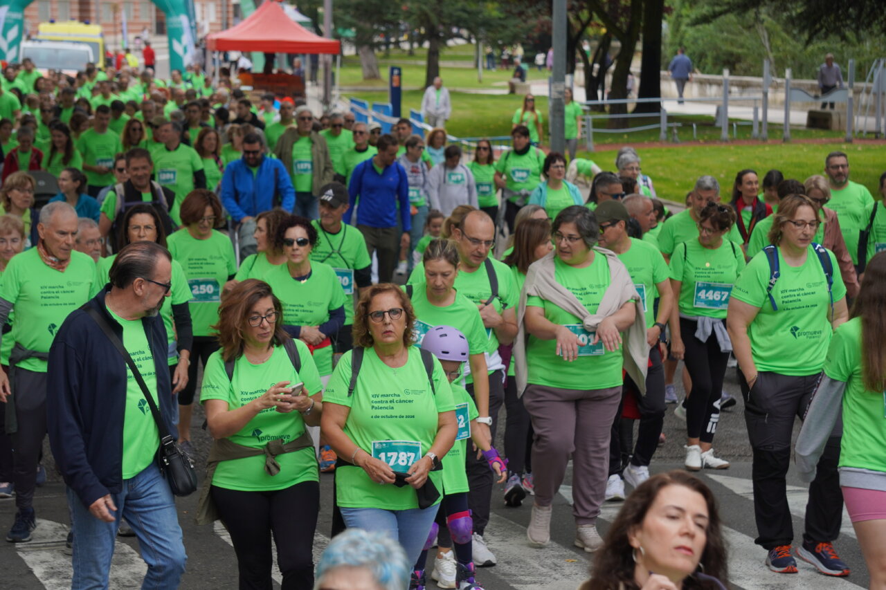 Participantes en la carrera contra el cáncer vistiendo camisetas verdes en Palencia