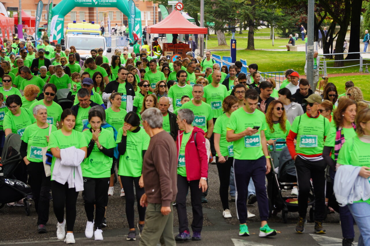 Participantes en la carrera contra el cáncer vistiendo camisetas verdes en Palencia