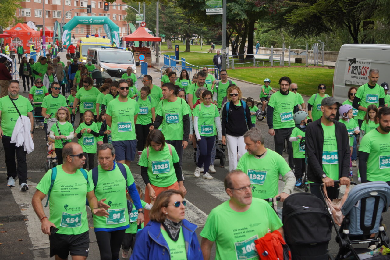 Participantes en la carrera contra el cáncer vistiendo camisetas verdes en Palencia