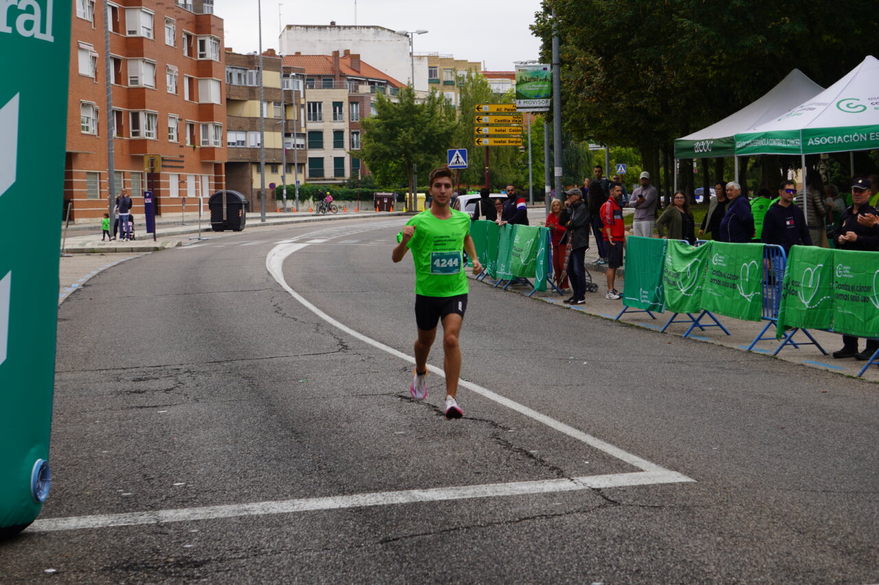 Corredor en la Carrera contra el Cáncer en Palencia con camiseta verde