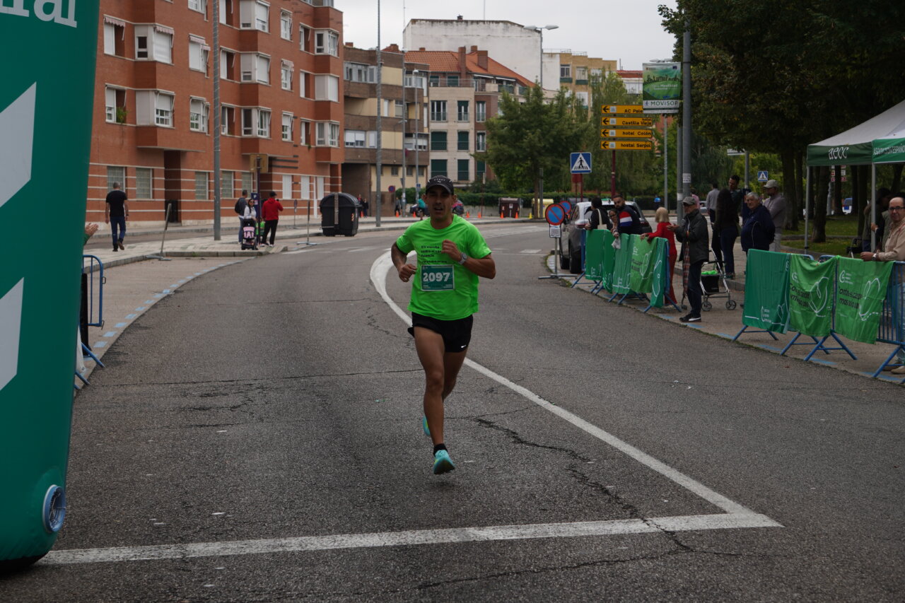 Corredor vestido de verde en la Carrera contra el Cáncer en Palencia