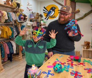 Un adulto y un niño juegan con piezas de construcción coloridas en una tienda.