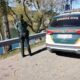 Agente de la Guardia Civil junto a un vehículo oficial en una carretera junto al agua