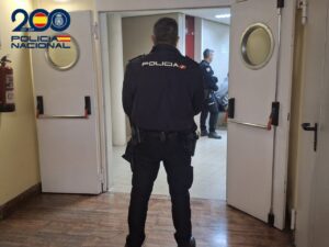Un agente de la Policía Nacional, de espaldas, observa a otro policía en una sala.