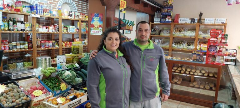 Pareja en tienda de alimentación con frutas y verduras frescas