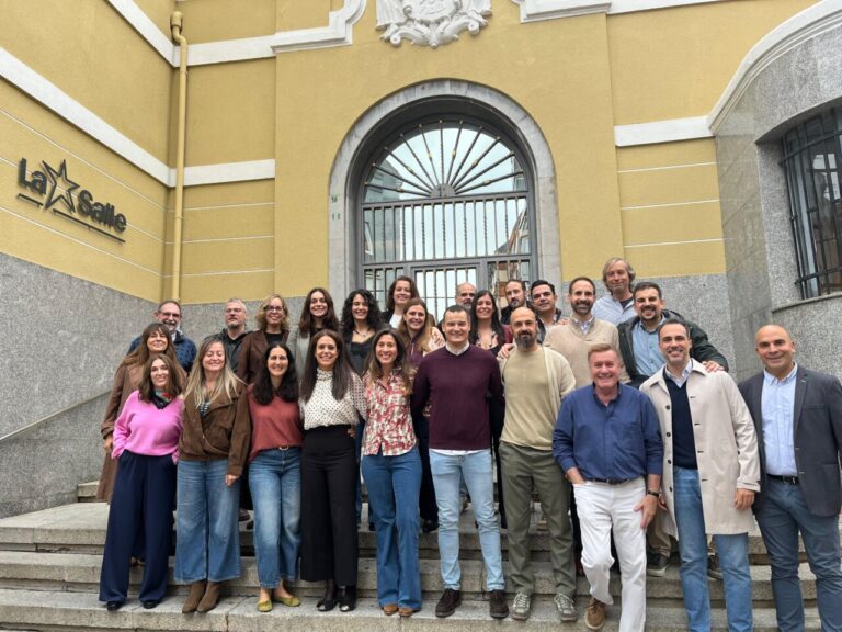 Grupo de antiguos alumnos posando ante la entrada del colegio La Salle en Palencia