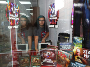 Joven en la tienda El Cubil del Mago con juegos de mesa y wargames