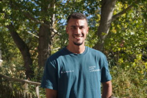 Bryan Clemente, jugador de fútbol del Palencia Cristo Atlético, sonriendo en un entorno natural.