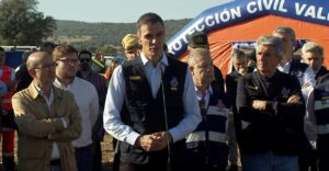 Un hombre habla ante un micrófono frente a una carpa de Protección Civil y varias personas.