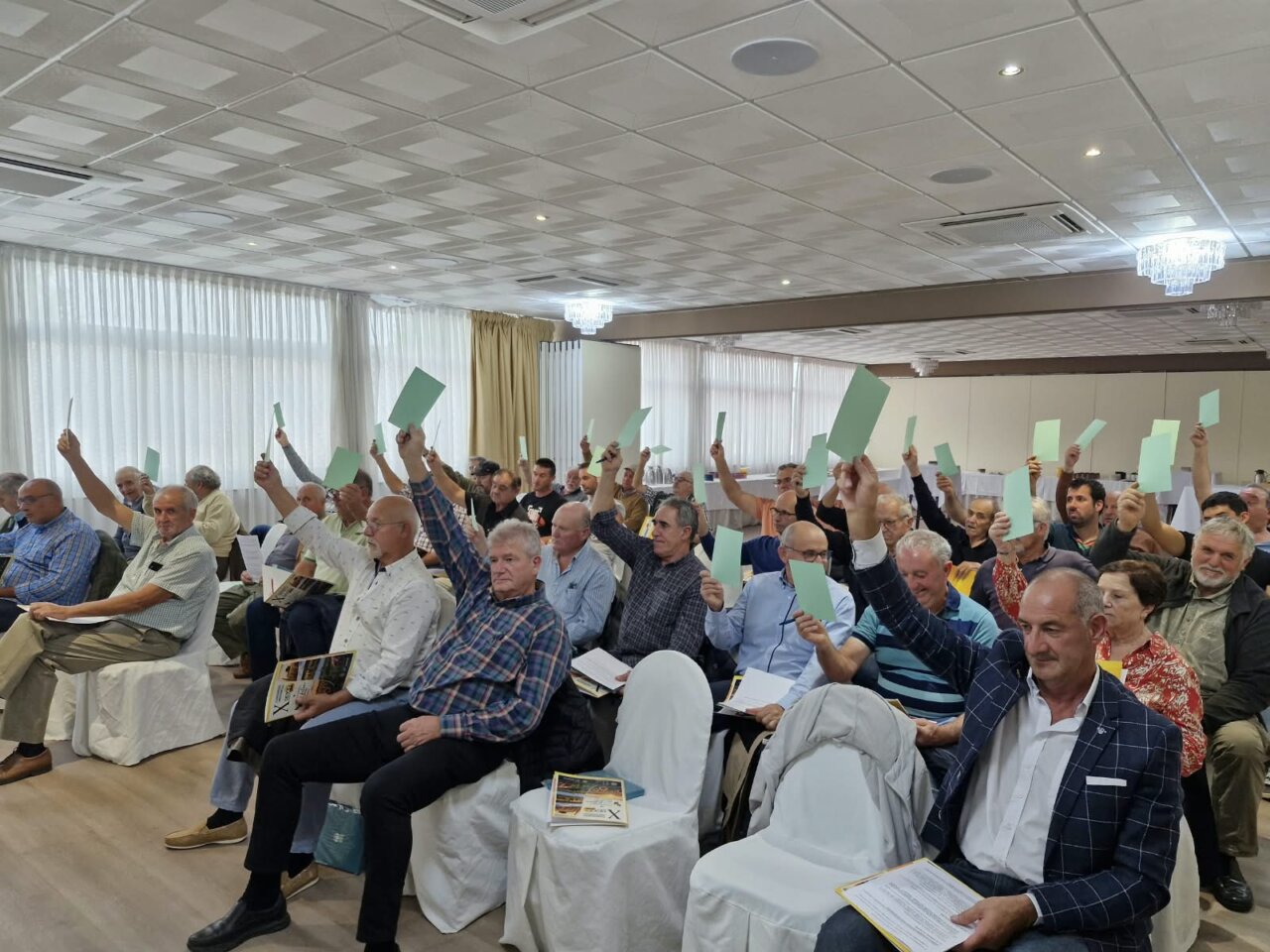 Asistentes al congreso de COAG Palencia levantando carteles de votación