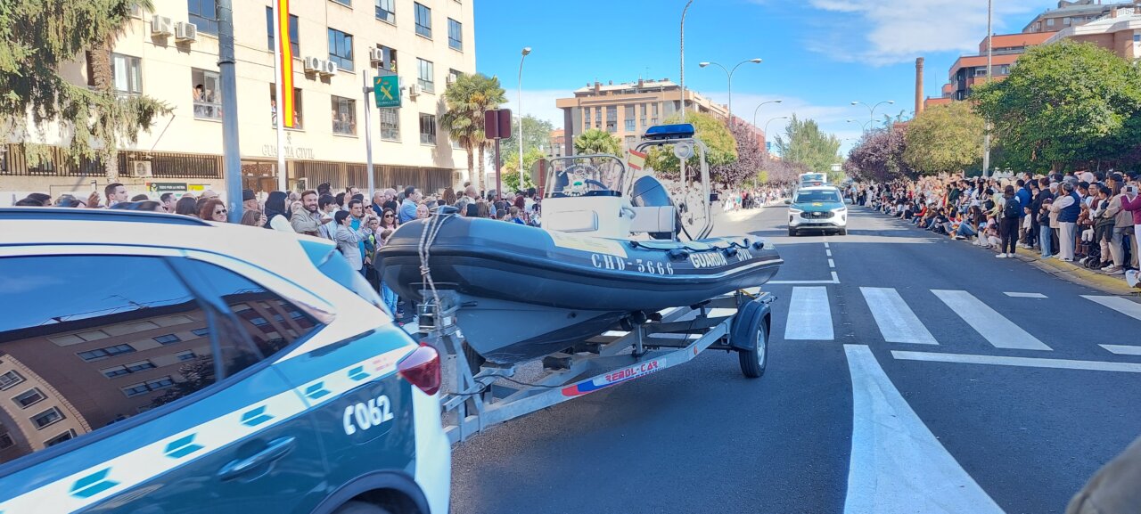 Desfile del Día de la Hispanidad con multitud de personas y vehículos