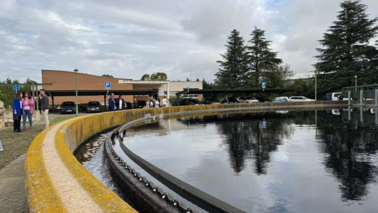 Vista de la estación depuradora de aguas residuales en Palencia con personas y árboles.