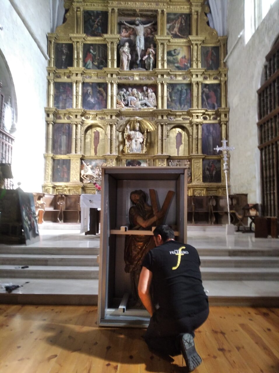 Un hombre preparando una escultura de San Andrés para su transporte