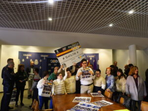 Varias personas posan ante un panel policial mientras muestran un cheque de Ruta 091.