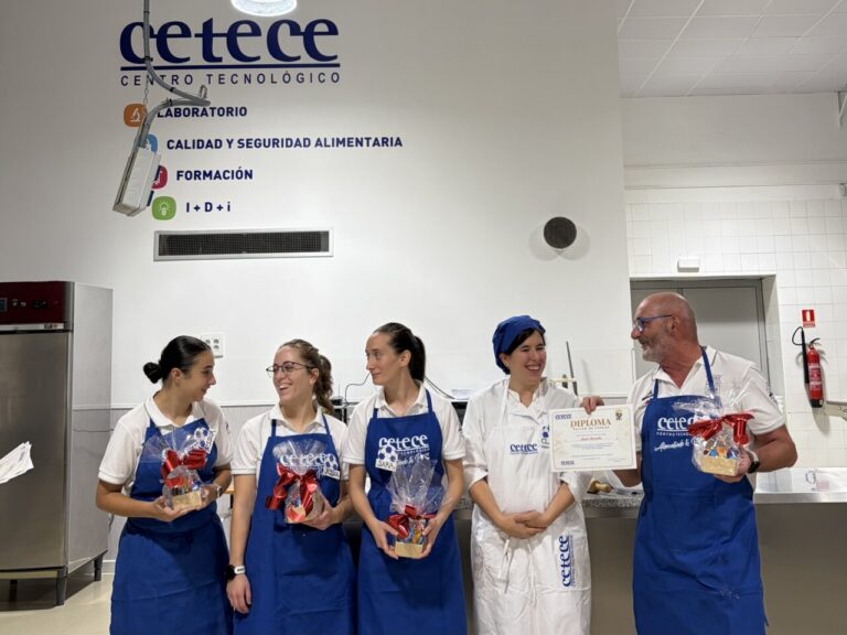 Grupo de personas en un centro tecnológico sosteniendo diplomas y regalos