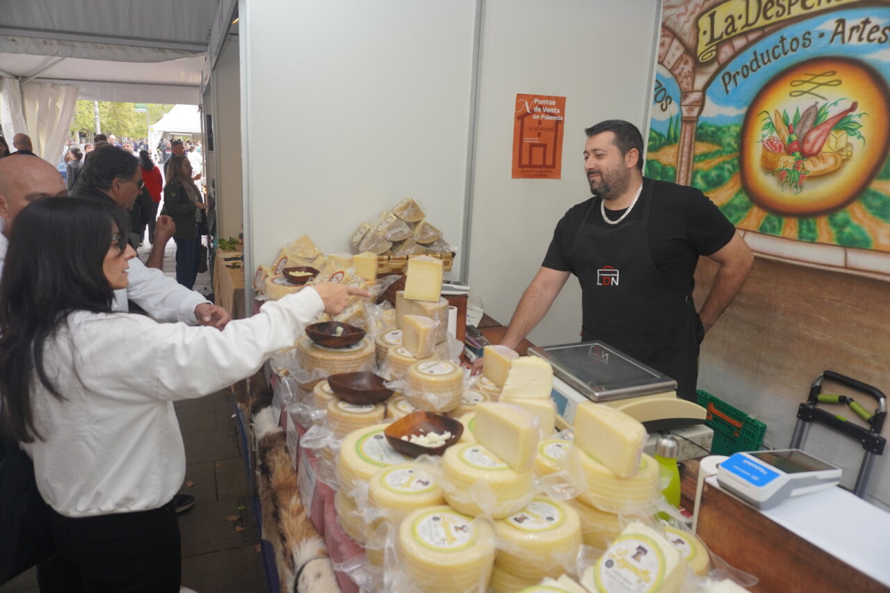 Mujer eligiendo quesos en un puesto de feria de productos artesanales