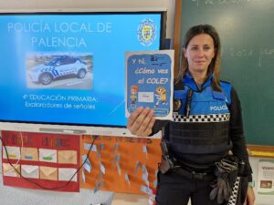 Agente de policía local de Palencia mostrando material educativo sobre educación vial.