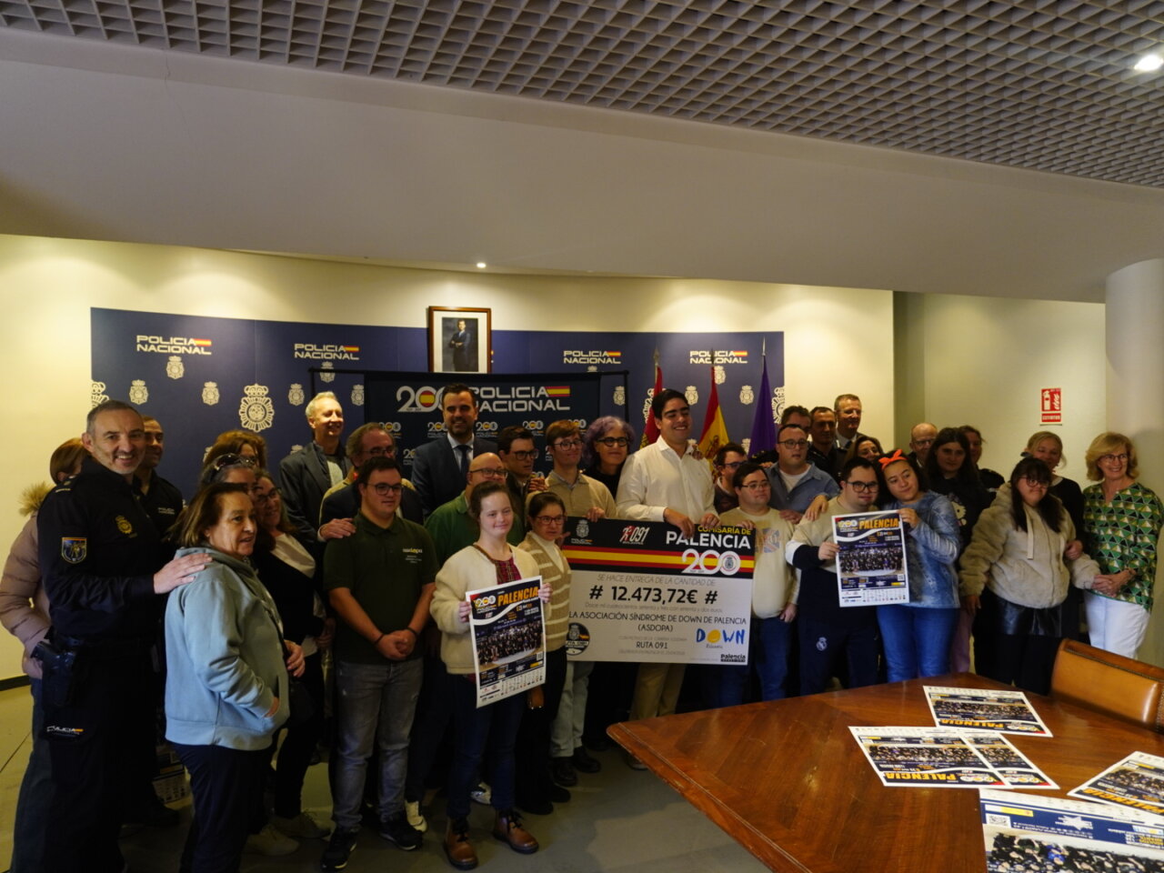 Grupo de personas posa junto a un cheque de 12.473,72 euros y carteles de la Ruta 091.