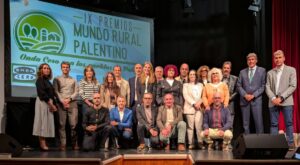Grupo de personas posa en un escenario ante el cartel de los premios Mundo Rural Palentino.