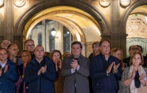 Un grupo de personas aplaude bajo un arco de piedra ornamentado.