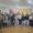 Varias personas posan en una sala ante carteles institucionales de Defensa en Palencia.