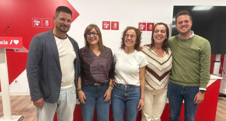 Cinco personas posan frente a paneles con los logotipos del PSOE de Palencia.