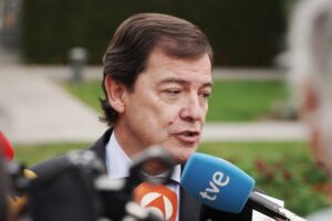 Hombre habla mientras varios micrófonos y cámaras lo rodean en exterior.
