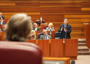 Un hombre interviene de pie ante varios asistentes sentados en una cámara legislativa.