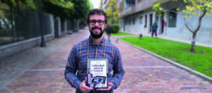 Un hombre con gafas sostiene un libro sobre la historia del periodismo español