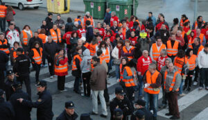 Manifestantes con chalecos naranjas en una huelga general por la vivienda
