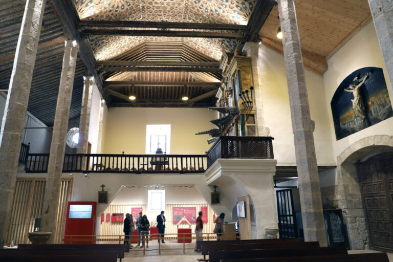 Interior de la iglesia de Fuentes de Nava con visitantes y detalles arquitectónicos