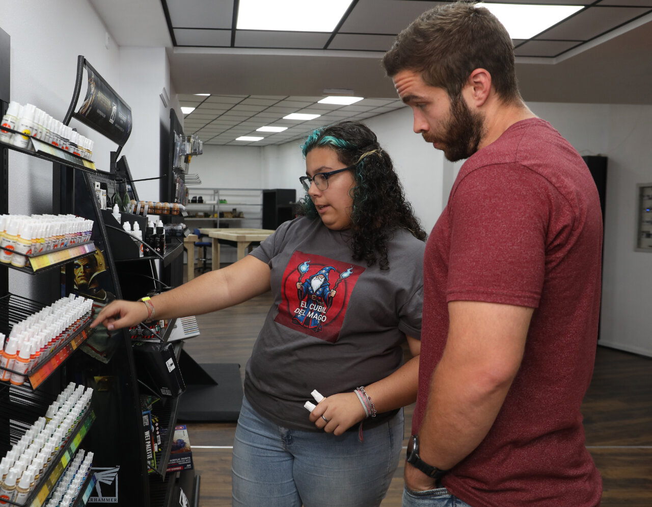Una joven mostrando productos en su tienda de juegos en Palencia.