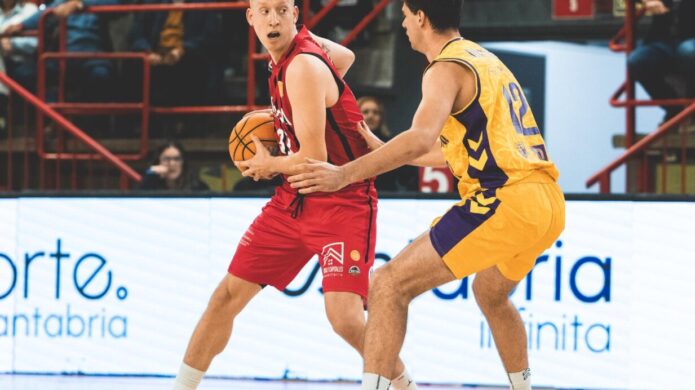 Dos jugadores de baloncesto disputan el balón durante una jugada en la cancha