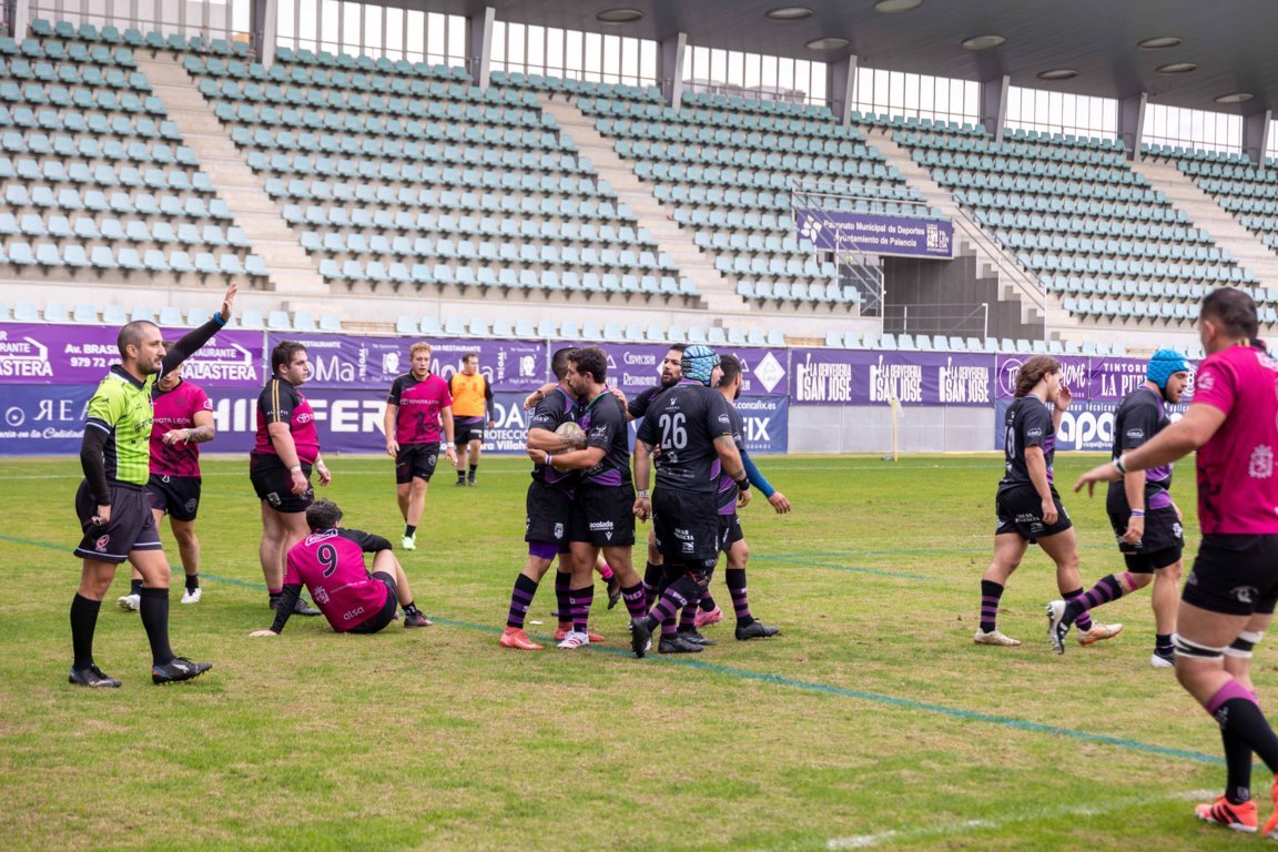 Jugadores de rugby sobre el campo, con un árbitro que levanta el brazo.