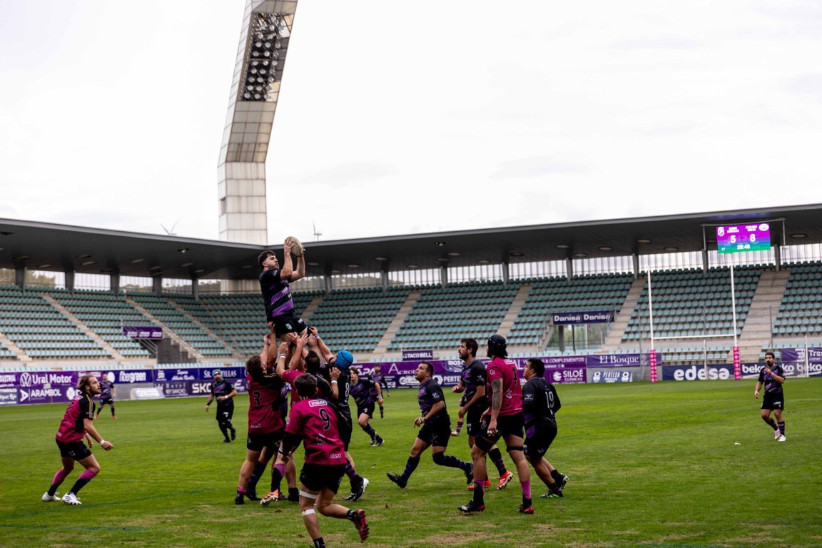 Un jugador de rugby salta para recibir el balón durante una touche en el campo