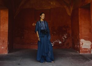 Fotógrafa Mirta Rojo posando en un lugar con paredes rojas