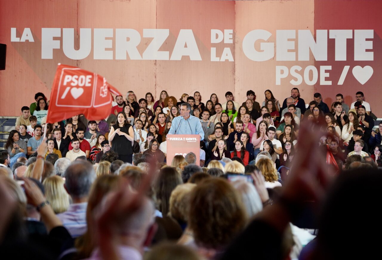 Pedro Sánchez habla desde un atril ante una multitud y banderas del PSOE