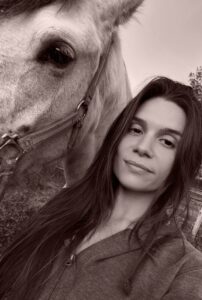 Fotografía en tono sepia de una mujer junto a un caballo, en primer plano.